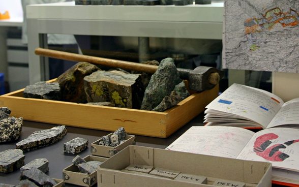 Marteau, carnet de terrain et échantillons de roche